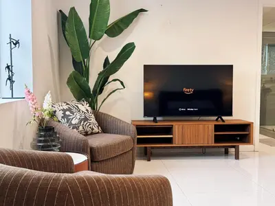 a living room with two chairs and a flat screen tv at Hollywood hill stunning view cozy private room in Los Angeles