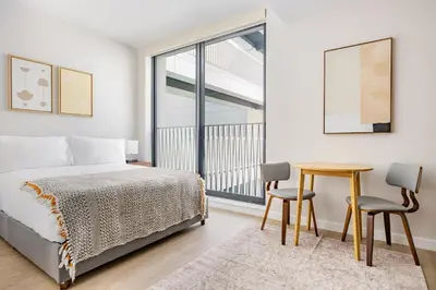 a bedroom with a bed and a table and chairs at Blueground Downtown elevator nr parks LAX-1245 in Los Angeles