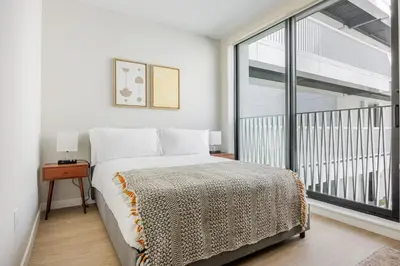 a bedroom with a bed and a large window at Blueground Downtown elevator nr parks LAX-1245 in Los Angeles