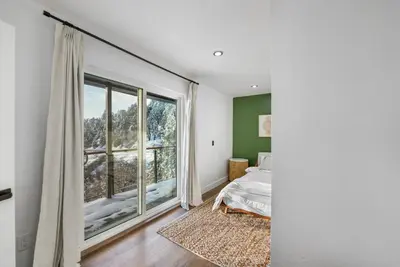 a bedroom with a bed and a large window at THE Cabin in Running Springs