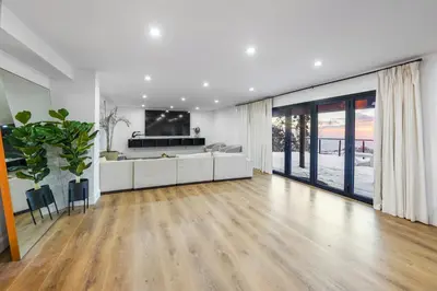 a living room with wooden floors and a large window at THE Cabin in Running Springs