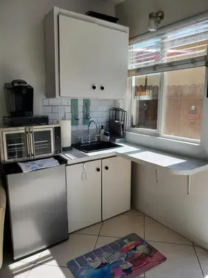 a kitchen with white cabinets and a sink and a window at Studio in Southbay close to the beach SoFi stadium LAX in Lawndale