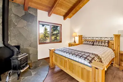 a bedroom with a bed and a wood stove at The Birdhouse #2529 in Big Bear Lake