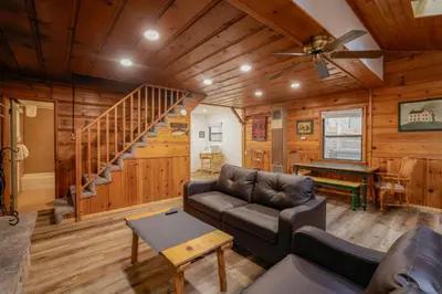 a living room with a couch and a staircase at Kelley's Kabin #290 in Big Bear Lake
