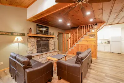 a living room with leather furniture and a stone fireplace at Kelley's Kabin #290 in Big Bear Lake