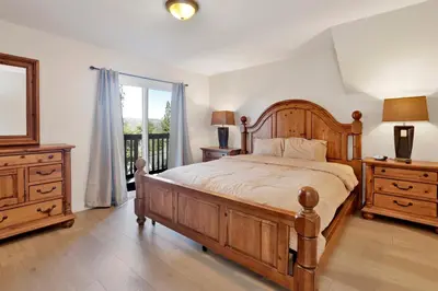 a bedroom with a large wooden bed and a window at Temple Bear Chalet #2507 in Big Bear Lake