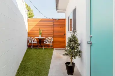 a courtyard with a table and chairs in a house at Sleek Luxury Studio with Patio LAX & Beach Access in Los Angeles