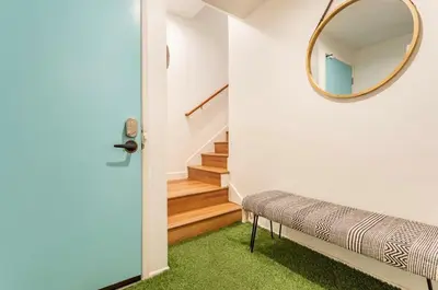 a hallway with a mirror and a bench and stairs at Exclusive Ocean & Pier View Family Escape in Manhattan Beach