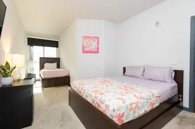 a bedroom with a bed and a dresser in it at Lovely 3BR Apt With Balcony And Rooftop Pool Plus Views in Los Angeles