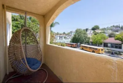 a balcony with a swing and a window with a school bus at Charming 2BR Condo with Onsite Parking Included in Los Angeles