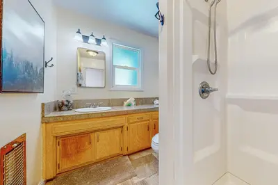 a bathroom with a sink and a toilet and a mirror at Tree-mendous Skypark-View Cabin in Skyforest