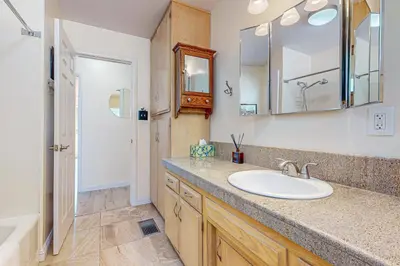 a bathroom with a sink and a mirror and a tub at Tree-mendous Skypark-View Cabin in Skyforest