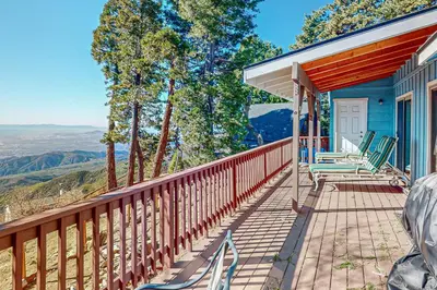 a porch of a blue house with chairs on it at Tree-mendous Skypark-View Cabin in Skyforest