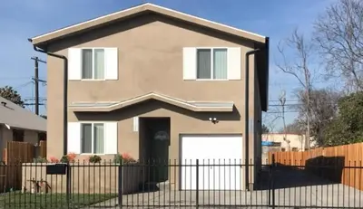 a house with a fence in front of it at VWM Hostel in Los Angeles