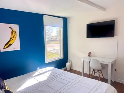 a bedroom with a blue wall with a bed and a desk at 4 Bed Modern Pool House with Spa & Game Room in Northridge Hospital Heliport