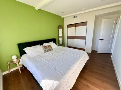 a green bedroom with a large bed with white sheets at 4 Bed Modern Pool House with Spa & Game Room in Northridge Hospital Heliport
