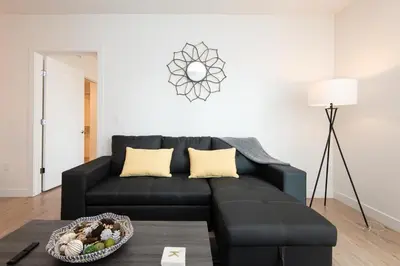 a black couch in a living room with a table at Chic 3-bed Apt with Pool & Hot Tub in Heart of DTLA in Los Angeles