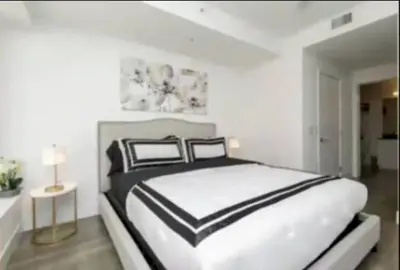a white bedroom with a black and white bed at Stunning 3 Bedroom High-Rise with Pool, Spa, and Rooftop Views in Los Angeles