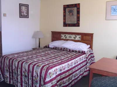 a bedroom with a bed with a colorful blanket at Budget Inn of Boron in Boron