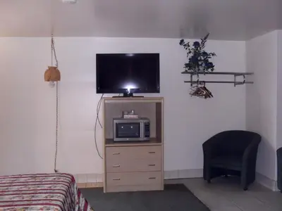 a bedroom with a tv on a dresser with a microwave at Budget Inn of Boron in Boron