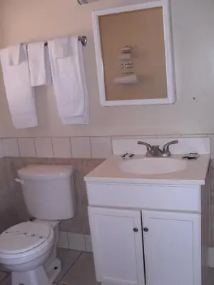 a bathroom with a toilet and a sink and a mirror at Budget Inn of Boron in Boron