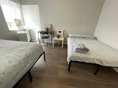 a bedroom with two beds and a table with a chair at The Disney Hostel - Fullerton - OC in Fullerton