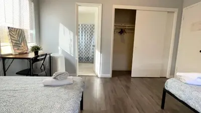 a room with two beds and a table and a closet at The Disney Hostel - Fullerton - OC in Fullerton