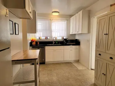 a kitchen with white cabinets and a sink and a window at Spacious 5BR Private Home 5 minutes to Rodeo Drive with Hot Tub Spacious Backyard Parking in Los Angeles