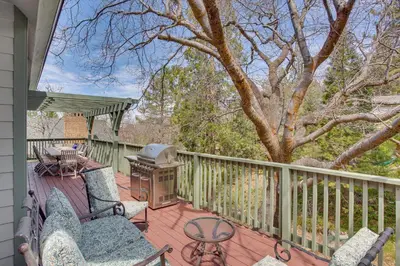 a porch with chairs and a grill and a tree at Game Room and Deck Pet-Friendly Lake Arrowhead Home in Lake Arrowhead