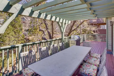 a porch with a table and chairs on a deck at Game Room and Deck Pet-Friendly Lake Arrowhead Home in Lake Arrowhead
