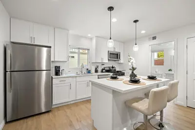 a kitchen with white cabinets and a stainless steel refrigerator at NEW Koreatown l Universal Studios in Vernon