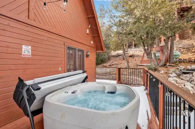 a hot tub on a balcony of a house at High-Top Lakeview Chateau Relaxing Modern Fawnskin Retreat in Fawnskin