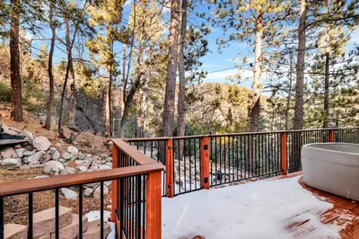 a wooden deck with a bath tub in the woods at High-Top Lakeview Chateau Relaxing Modern Fawnskin Retreat in Fawnskin
