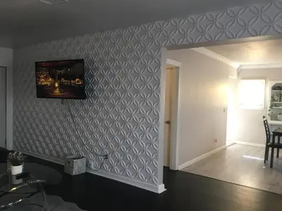 a living room with a wall with a gray geometric wallpaper at 4bed 2ba Hollywood house Block away from sunset, Free parking, private backyard in Los Angeles