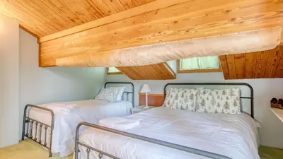 a bedroom with two beds and a wooden ceiling at Lakefront w Private Dock Hot Tub Large Deck Views Lakeside on Lagunita in Big Bear Lake