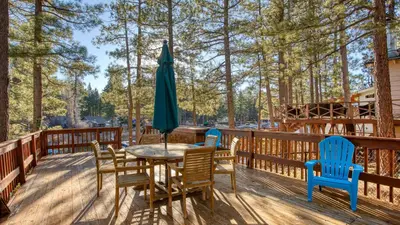 a table with chairs and an umbrella on a deck at Lakefront w Private Dock Hot Tub Large Deck Views Lakeside on Lagunita in Big Bear Lake