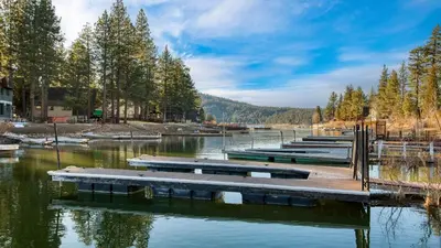 a row of boats on a river with trees at Lakefront w Private Dock Hot Tub Large Deck Views Lakeside on Lagunita in Big Bear Lake