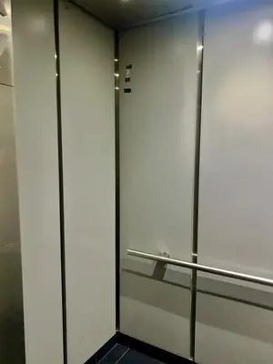 a bathroom with white walls and a metal railing at Masion de Beverly Hills in Los Angeles