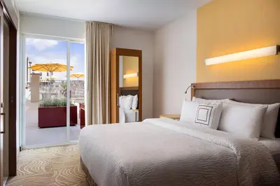 a hotel room with a bed and a balcony at SpringHill Suites by Marriott Los Angeles Burbank/Downtown in Burbank