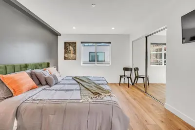 a bedroom with a large bed and a table at Luxe Townhome Newly-Built in Sherman Oaks Community Hospital Heliport