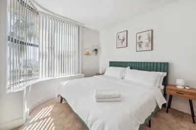 a white bedroom with a large bed and windows at Marina del Rey getaway,Free parking,Pool,Hot Tub in Los Angeles