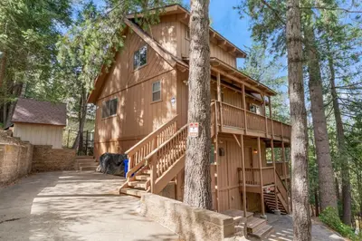 a cabin in the woods with a staircase leading up to it at Cozy Owl Lodge, Central AC & Hea, Spa Tub & BBQ in Lake Arrowhead
