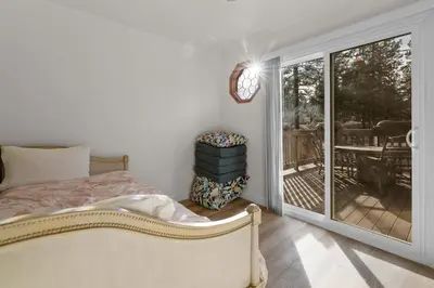 a bedroom with a bed and a sliding glass door at Big Bear Cottage - Walk to Lake, Smart TV, Fireplace, Deck in Big Bear Lake