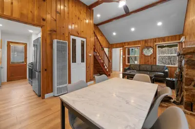 a dining room and living room with a table and chairs at Big Bear Cottage - Walk to Lake, Smart TV, Fireplace, Deck in Big Bear Lake