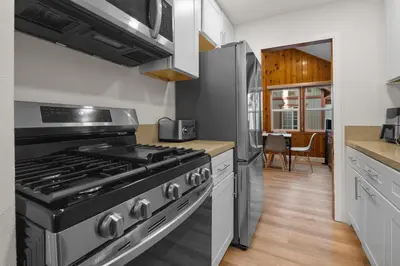 a kitchen with a stove and a refrigerator at Big Bear Cottage - Walk to Lake, Smart TV, Fireplace, Deck in Big Bear Lake