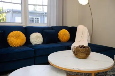 a blue couch with yellow pillows and a table at Sunny SoCal Escape 3BR 2BA Bright home with pool in Winnetka