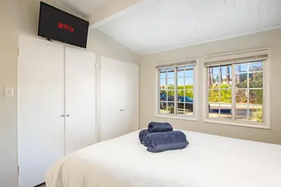 a bedroom with a bed with a tv on the wall at Sunny SoCal Escape 3BR 2BA Bright home with pool in Winnetka