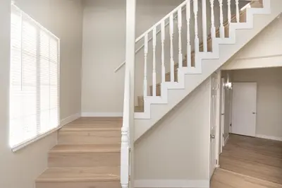 a staircase in a home with white walls and wood floors at Sunny SoCal Escape 3BR 2BA Bright home with pool in Winnetka
