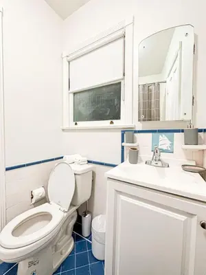 a bathroom with a toilet and a sink and a mirror at Elegant 4-Bedroom with Courtyard - WIL- BEV in Los Angeles