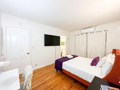 a bedroom with a bed and a flat screen tv at Elegant 4-Bedroom with Courtyard - WIL- BEV in Los Angeles